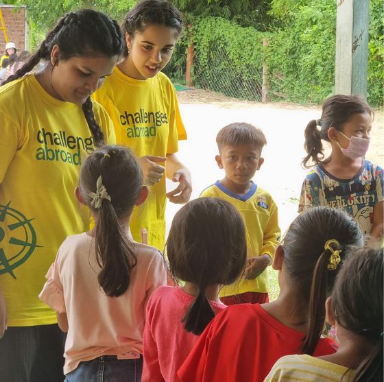 Two Challenges Abroad team members talking to a group of children in Cambodia
