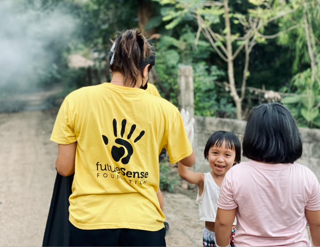 Future Sense Foundation team member high fiving a kid - Challenges Abroad