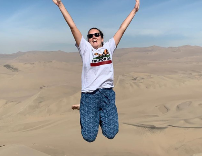 Challenges Abroad team member Lizzie celebratory jumping in the desert