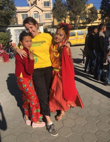 Challenges Abroad team member in the middle of two women in traditional dress from Nepal