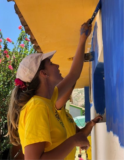 Challenges Abroad team member in Peru painting a wall blue