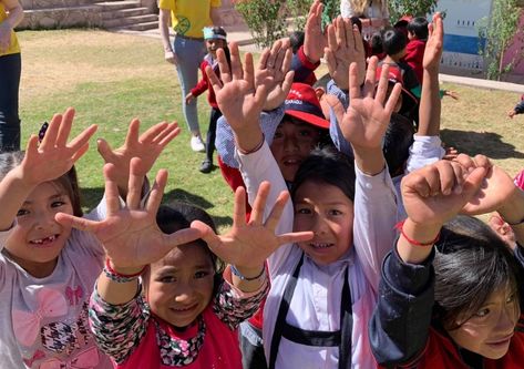 A group of Peru students reaching up their hands - Challenges Abroad