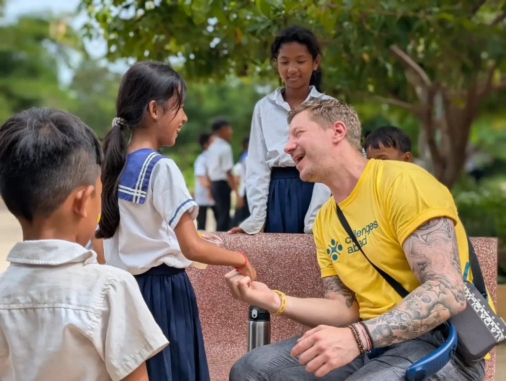 Challenges Abroad participant laughs with local school children in Cambodia