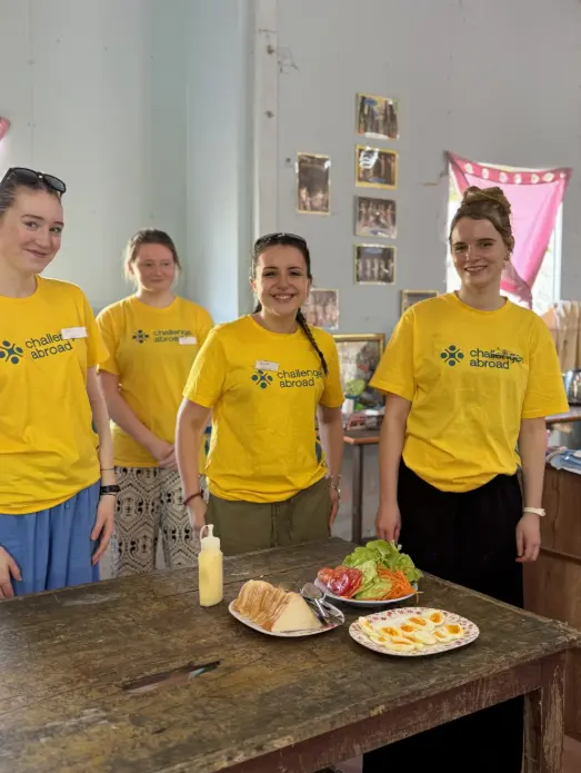 Queen Mary College students preparing food and taking part in a cultural community experience in Thailand.