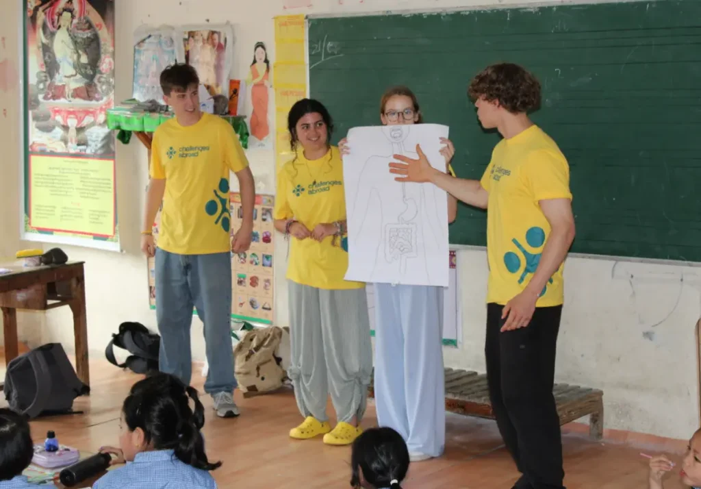 Queen Mary College students presenting interactive educational activities in a classroom during their India programme.