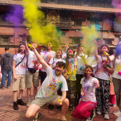 Group of students with colour powder in the air around them